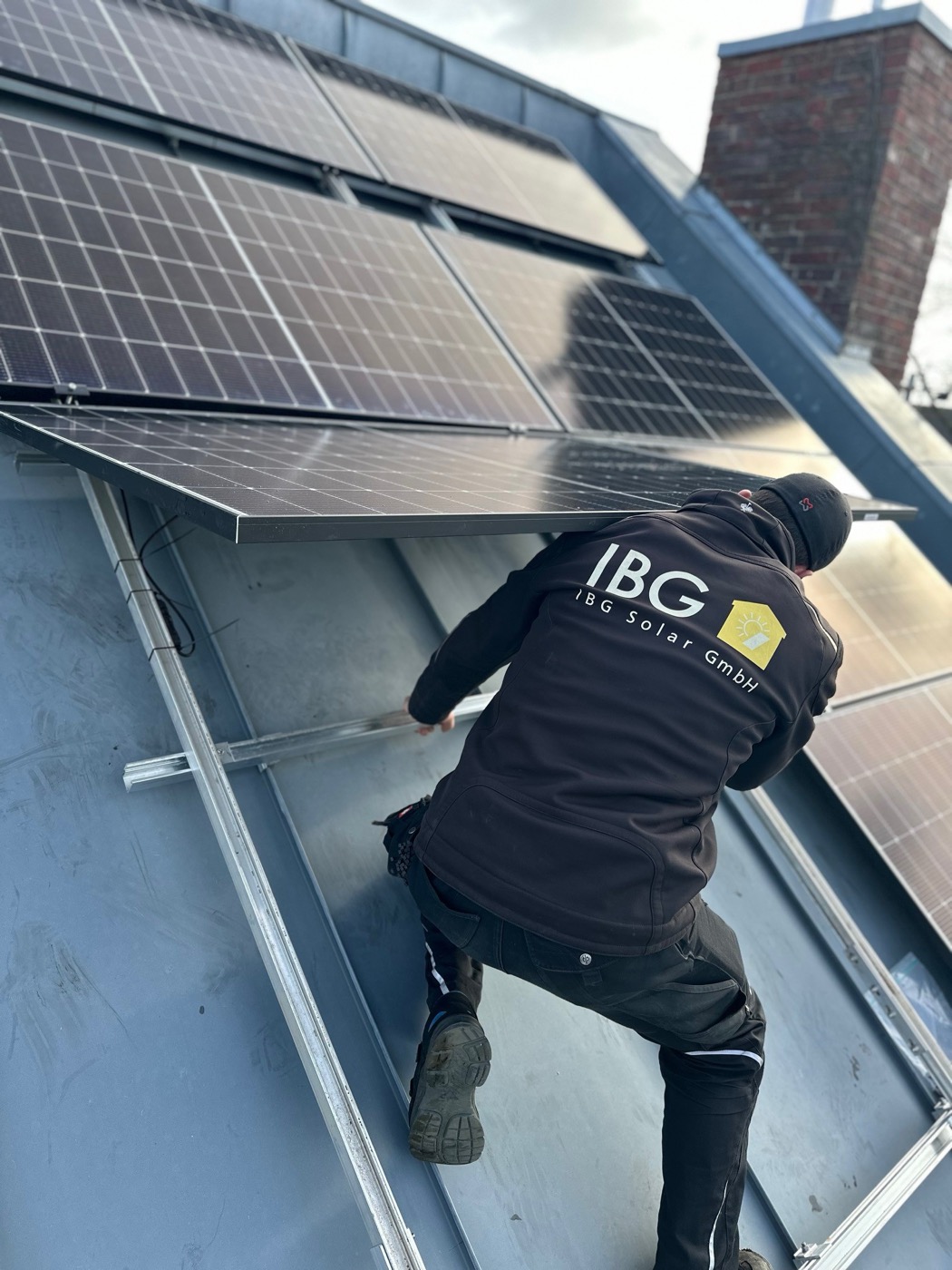 Mitarbeiter von IBG Solar montiert Solarmodule auf einem Dach
